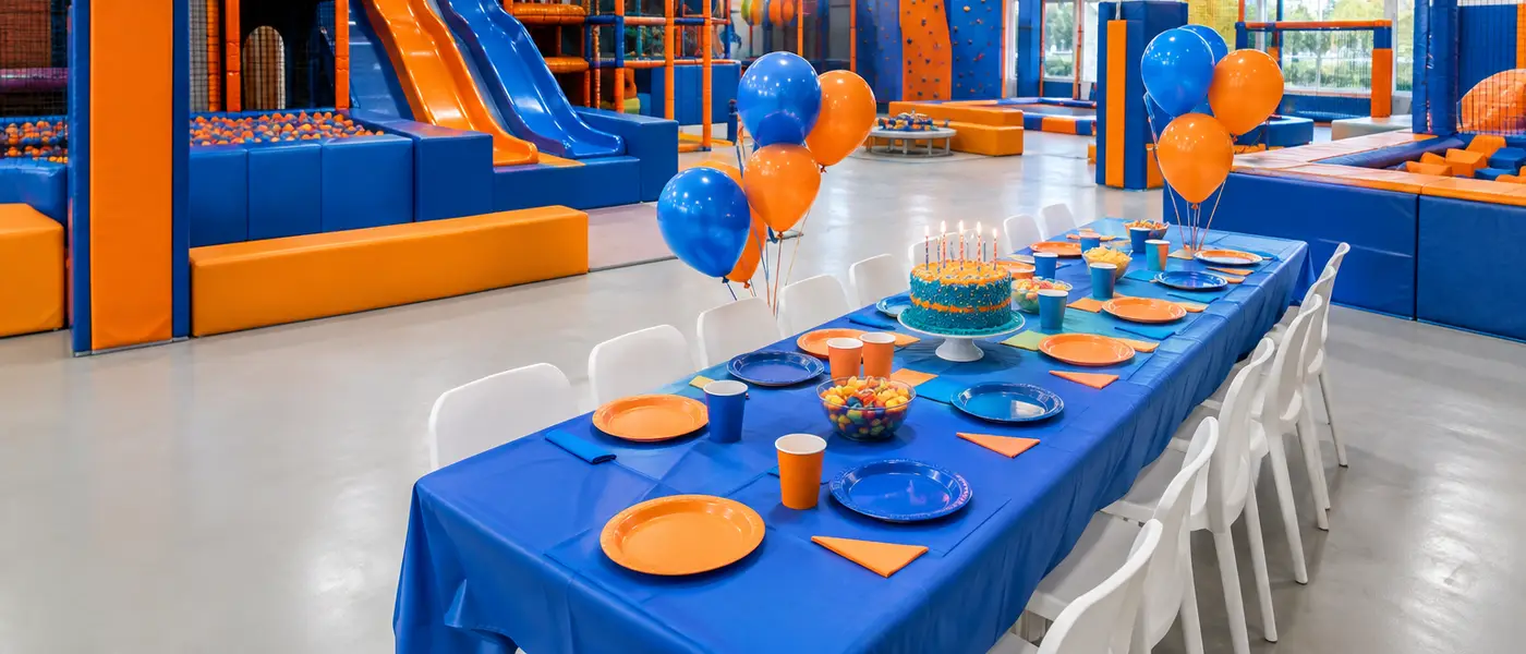 Mesa de aniversário posta com toalha azul e balões